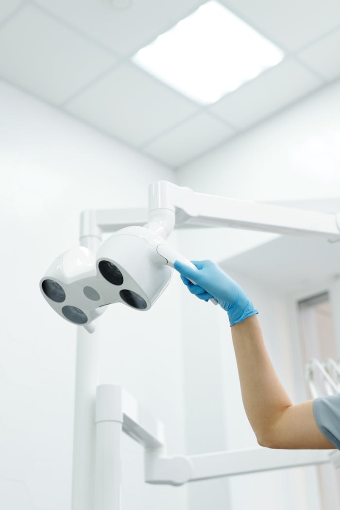 Close-up of a dentist adjusting dental light in a clinic with modern equipment.